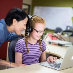 teacher helping student with assessment.